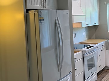 a fridge relocated to fit under custom cabinetry